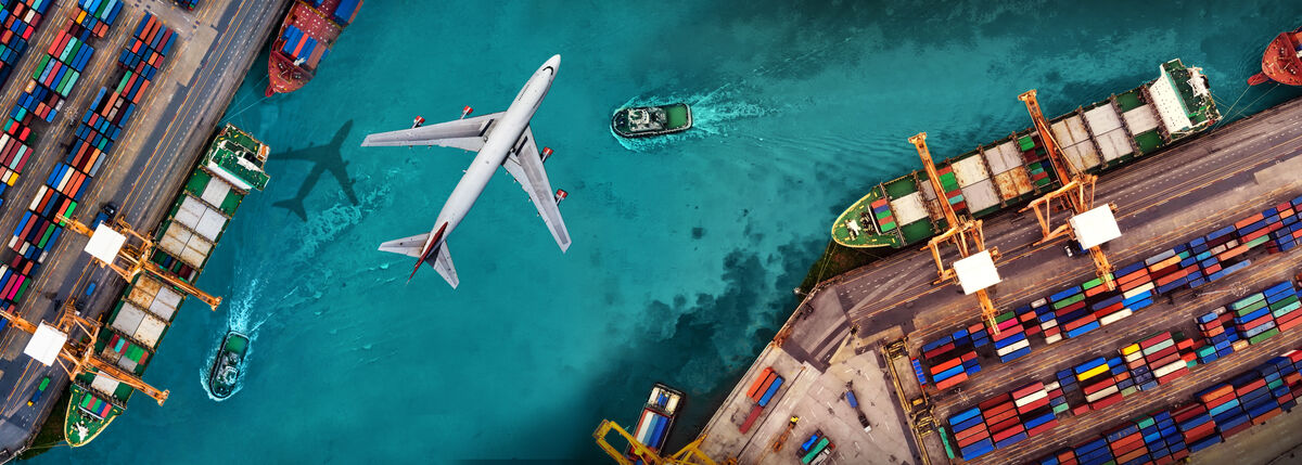 Bird's eye view of plane flying over a port terminal