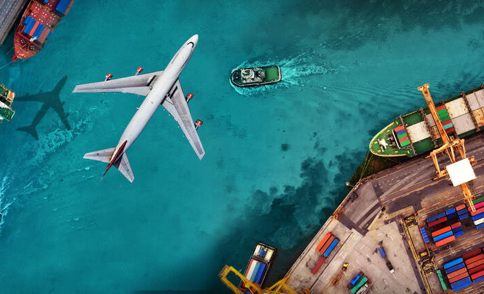 Bird's eye view of plane flying over a port terminal